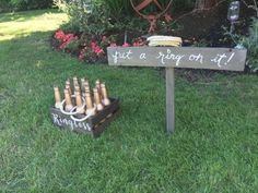 a wooden sign that says put a ring on it next to some wine bottles in the grass