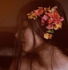 a woman with flowers in her hair is staring at the camera while she's back to the camera