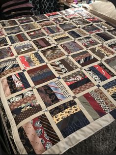 a bed with a quilt made to look like it has many different ties on it