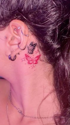 a woman with a butterfly tattoo on her neck and behind the ear is a chain