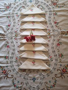 four napkins are arranged in the shape of a christmas tree on a tablecloth