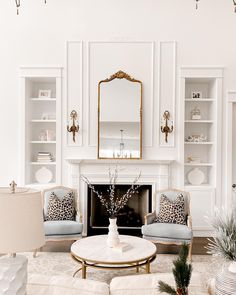 a living room filled with furniture and a fire place in front of a white fireplace