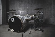 a drum set is sitting in the middle of a room with concrete walls and flooring