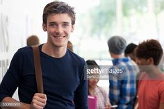 a man is smiling and holding a bag in front of him while other people look on