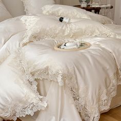 a bed with white comforters and pillows on it