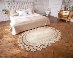 a white bed sitting on top of a hard wood floor next to a wooden dresser