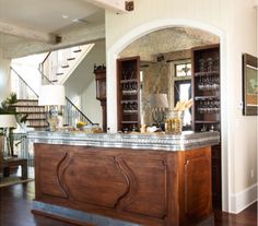 a kitchen with an island in the middle of it and stairs leading up to the second floor