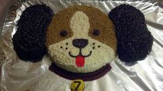 a cake shaped like a dog with its tongue out