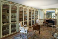 a living room filled with lots of furniture and bookshelves