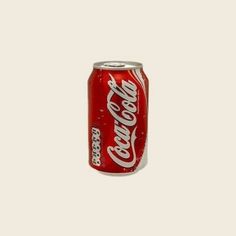 a can of coca cola on a beige background