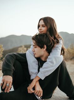 a man sitting on top of a woman's back while she holds her in the air