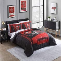 a bedroom with a black and red comforter set