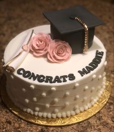 a graduation cake decorated with pink roses and a mortaron on top that says congrat's man