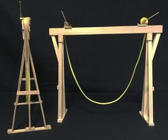 two pieces of wood with wires attached to them on a black background in front of a blue backdrop