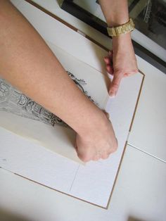 a woman's bare foot is on top of a piece of paper