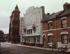 there are many buildings on this street and one has a clock tower in the middle