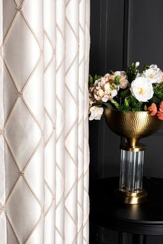 a vase filled with flowers sitting on top of a black table next to a window