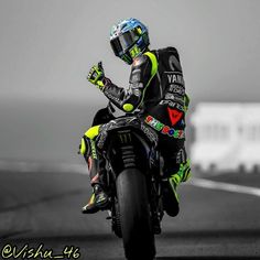 a man riding on the back of a motorcycle down a race track