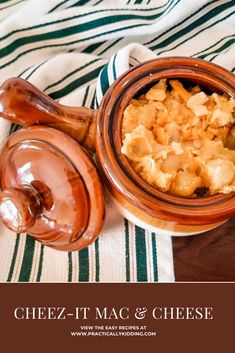 a bowl of food sitting on top of a striped table cloth next to a wooden spoon