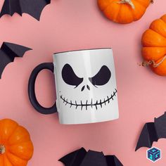 a coffee mug with a skeleton face on it surrounded by bats and orange pumpkins