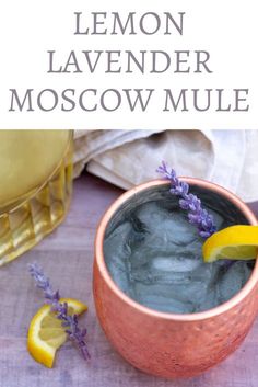 a drink in a copper cup with lavender and lemon garnish