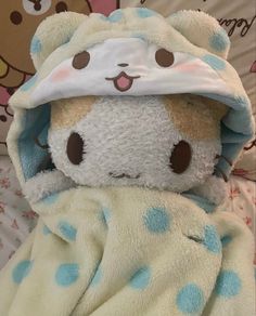 a teddy bear wrapped in a blanket with polka dots on it's head and eyes