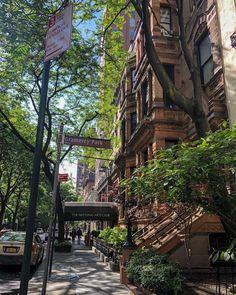 an apartment building on the corner of a city street with people walking down the sidewalk