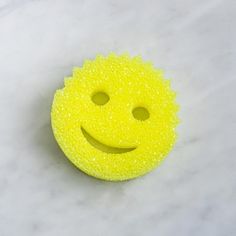 a yellow smiley face scrubber sitting on top of a white counter