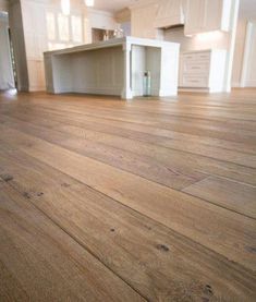 an empty room with hard wood floors and white cabinetry in the backround