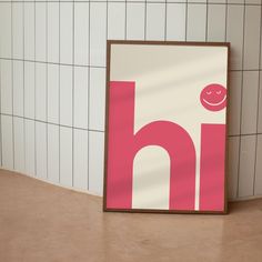 a pink and white letter h with a smiley face on it next to a tiled wall