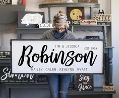 a woman is holding a sign that says robinson in black and white lettering on it