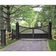 a gated driveway leading into a lush green park