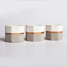 three white vases with brown stripes on them