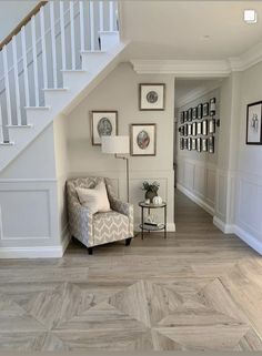 a living room filled with furniture next to a stair case and wooden floored stairs