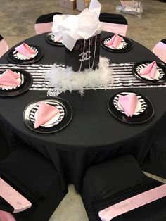 a table set up with black and pink napkins