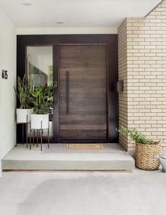 a front door with potted plants next to it