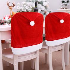 two red chairs with buttons on them sitting in front of a white table and christmas tree