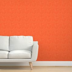 a white couch in front of an orange wall