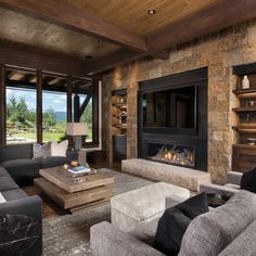 a living room filled with furniture and a fire place next to a large glass window