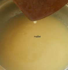 the liquid is being poured into the pot to make something yellow or brown in it