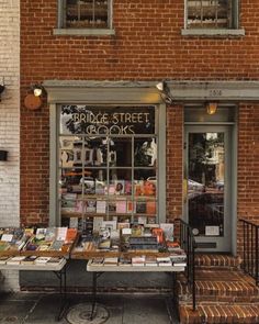 a table with books on it in front of a brick building that says bridge street books