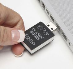 a hand holding a small black and white usb device