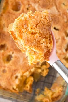 a spoon with some food in it on top of a glass dish filled with batter