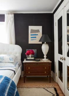 a bedroom with black walls and white furniture