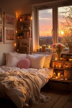 a bedroom with candles and pictures on the wall next to a bed in front of a window