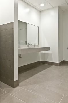 an empty bathroom with two sinks and mirrors