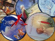 four coasters with christmas designs on them sitting on a wooden table next to a red ribbon