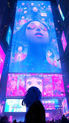 a woman standing in front of a giant screen with images on it's walls