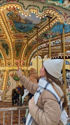 a woman taking a selfie with her cell phone in front of a merry go round