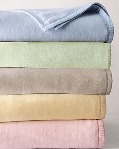 towels stacked on top of each other in various colors and sizes, all folded up